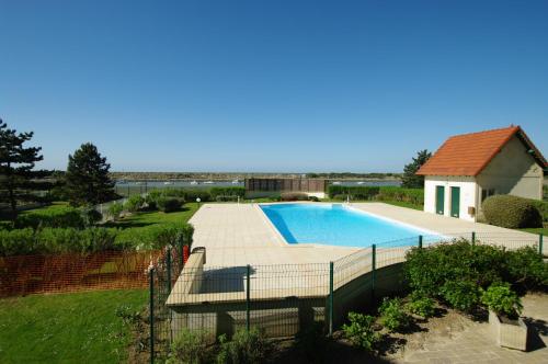 een zwembad in een tuin naast een huis bij charmant appartement port de Dives sur mer in Dives-sur-Mer