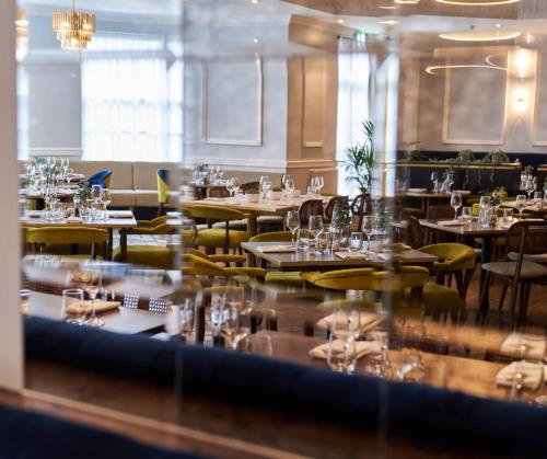 a restaurant with tables and chairs with glasses on them at Shaw Hill Hotel Golf And Country Club in Chorley