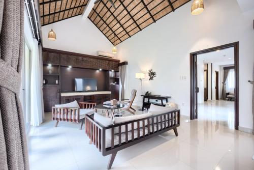 uma sala de estar com um sofá e uma mesa em THE BLOSSOM RESORT ISLAND - All Inclusive em Da Nang