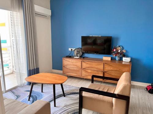 sala de estar con TV y tocador de madera en Seaview Mercure Hotel Suite KK City Center, en Kota Kinabalu