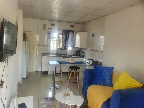a living room with a blue couch and a kitchen at BlueView Apartments in Kitwe