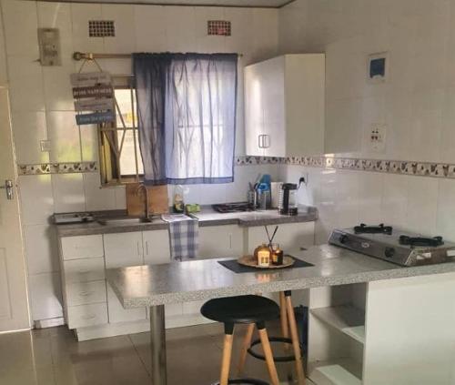 eine Küche mit einer Theke und einem Tisch darin in der Unterkunft BlueView Apartments in Kitwe
