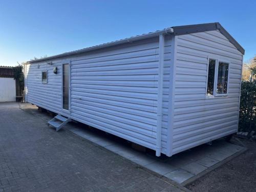 a large white shed sitting on top of a driveway at Bredeneeker Gasthaus in Rastorf