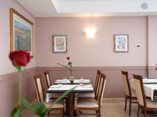 a dining room with a table with a flower on it at Hotel SAN PIO in San Giovanni Rotondo
