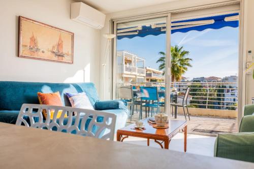 un salon avec un canapé, des chaises et une table dans l'établissement 3-Br Apartment Terrace steps from Beaches, à Cannes