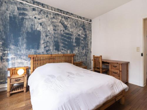 um quarto com uma cama e uma parede azul e branca em Residence Louis Quartier Centre Ville em Vittel