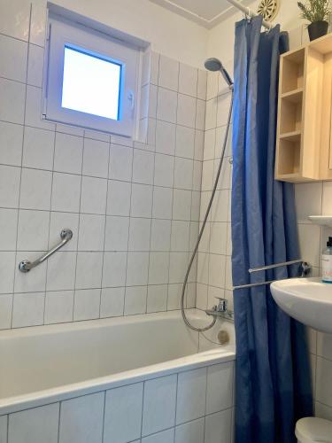 a bathroom with a tub and a shower curtain at am Deich 6 pers House with a private terrace behind a dike by the Lauwersmeer in Anjum