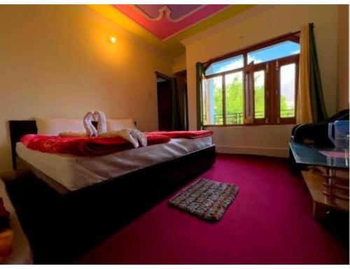 a bedroom with a large bed and a window at Hotel Auli Inn, Joshimath in Joshīmath