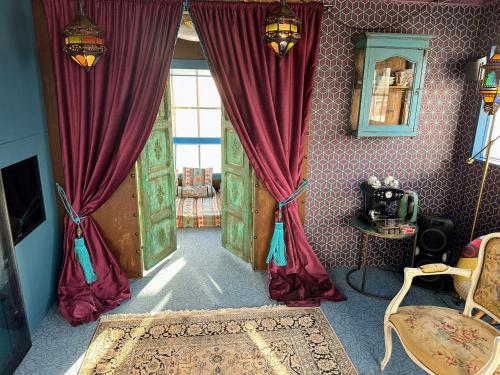 uma sala de estar com cortinas vermelhas e uma janela em Crane Hotel Faralda em Amsterdã