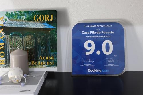 a book and a candle on a shelf next to a sign at Casa File de Poveste in Târgu Jiu