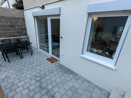 a patio with a table and chairs and a window at Haas Apartments Slepa, city centre, parking, courtyard in Brno