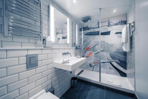 a white bathroom with a sink and a shower at Mercure London Bridge in London