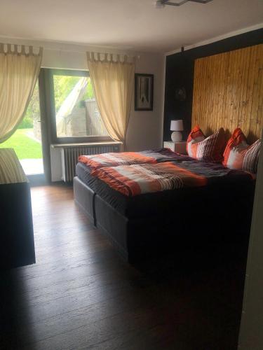 a bedroom with a large bed with a large window at Ferienwohnung mit Blick auf den See in Öhningen