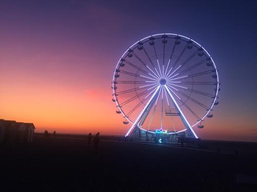 - une grande roue au coucher du soleil sur la plage dans l'établissement Charmant studio à Ouistreham, à Ouistreham