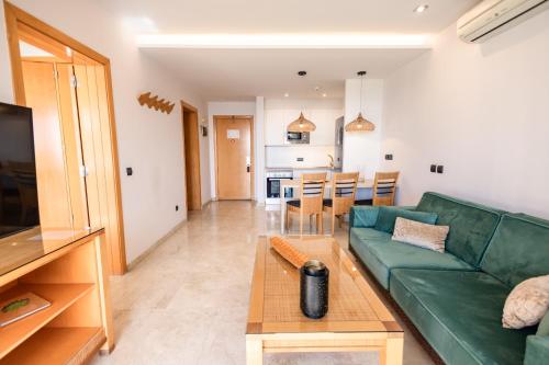a living room with a green couch and a table at Serenity Amadores in Puerto Rico de Gran Canaria