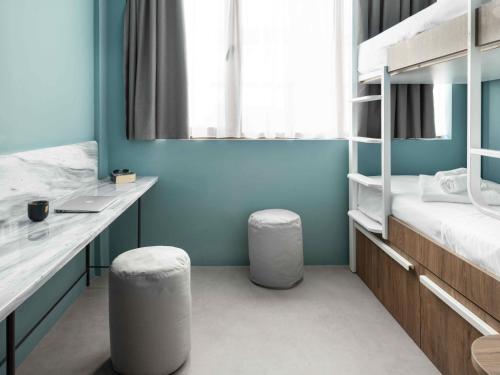 a room with two bunk beds and two stools at Zeus is Loose Hostel in Thessaloniki
