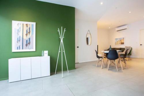 a living room with a table and a green wall at Lesplanade By Wynwood House in Panama City