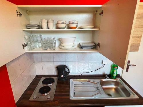 eine kleine Küche mit einer Spüle und einem Herd in der Unterkunft FEWO2-1 Zim Apart-5 Bett-Küche-Dusche WC-Parkplatz in Berlin