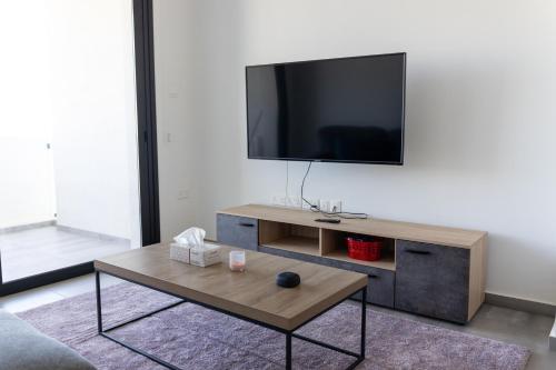 uma sala de estar com uma televisão e uma mesa de centro em Διαμερισμα 1 υπνοδωματίου em Aglantzia
