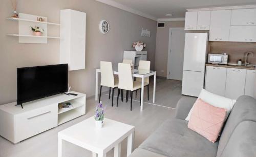 een woonkamer met een bank en een tafel en een keuken bij DiP HOME APARTMENTS in Pomorie