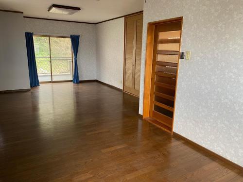 um quarto vazio com pisos de madeira e uma porta em Kashibesso Kiteki - Vacation STAY 26650v em Kitakyushu