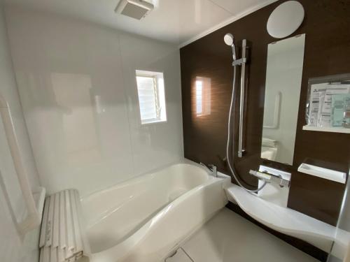 uma casa de banho branca com uma banheira e um lavatório em Kashibesso Kiteki - Vacation STAY 26650v em Kitakyushu