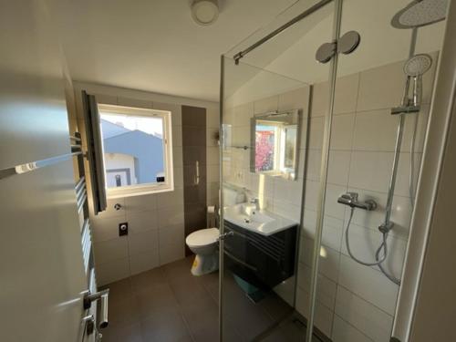 een badkamer met een douche, een wastafel en een toilet bij Apartmani BURIN in Nin