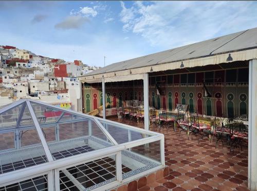 un bâtiment avec des tables et des chaises sur le toit dans l'établissement Riad Las Mil y una Noches Tetuan, à Tetouan