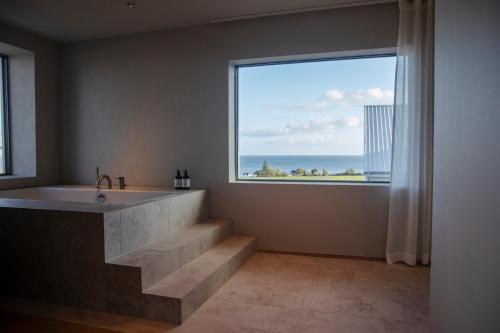 Hotel Vyn في سيمريسهامن: حمام مع حوض استحمام و نافذة كبيرة