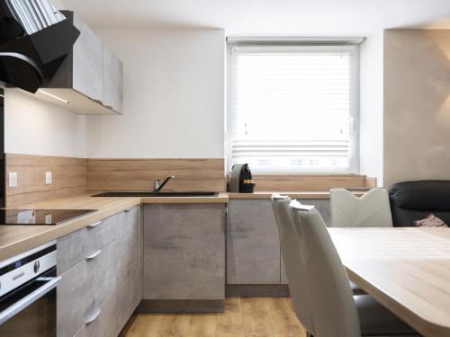 a kitchen with a table and a sink and a window at Residence Louis Quartier Casino in Vittel