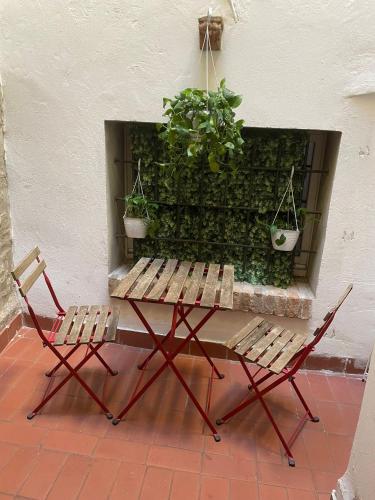 a picnic table with two chairs and two potted plants at Green Rooms Ferrara in Ferrara