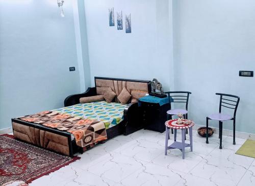 1 Schlafzimmer mit einem Bett, 2 Stühlen und einem Tisch in der Unterkunft Rooftop Floor with a big Room in Neu-Delhi