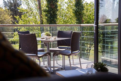 a patio with a table and chairs on a balcony at Les Ormes Resort in St Brelade