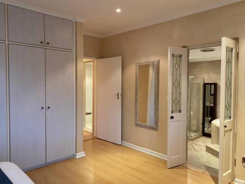 a bedroom with a large closet and a mirror at A Home in Timour Hall in Cape Town