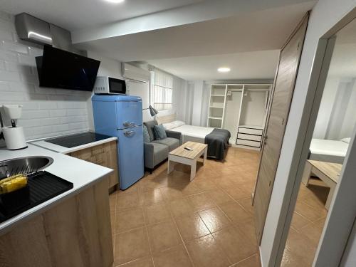 a small kitchen and living room with a blue refrigerator at Apartamento Avenida Velazquez Planta Baja in Málaga