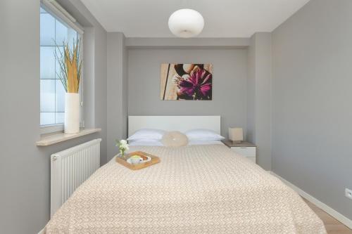 a bedroom with a bed with a tray on it at Bright and Cosy Apartment with Balcony in Gdynia by Renters in Gdynia