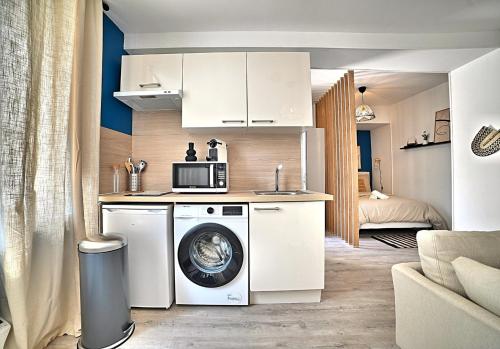 uma cozinha com uma máquina de lavar roupa e um micro-ondas em L'escapade Fourasine - Heart of Fouras em Fouras