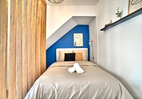 um quarto com uma cama com uma parede em tons de azul em L'escapade Fourasine - Heart of Fouras em Fouras