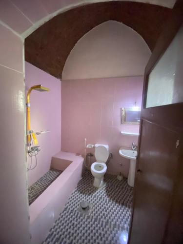 uma casa de banho com uma banheira, um WC e um lavatório. em Villa Habu em Al Aqālitah