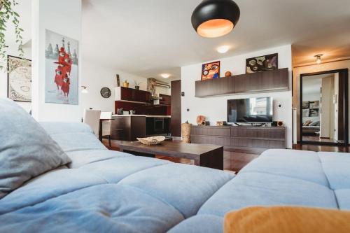 a living room with two blue couches and a kitchen at Cozy Nest in quiet neighbourhood, free parking in Ljubljana