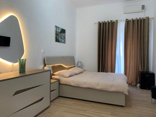 a bedroom with a bed with a dresser and a mirror at Mateo in Himare