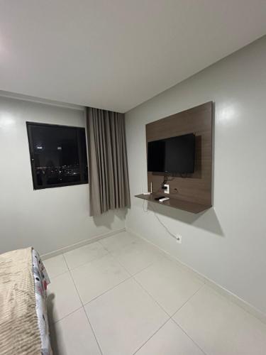 um quarto de hotel com uma televisão e uma cama em Apto confort bem localizado Macambira em Campina Grande