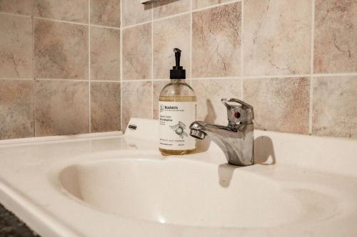 a bottle of soap sitting on top of a sink at Wave Side Cottage Scamander Sleeps 5 in Scamander