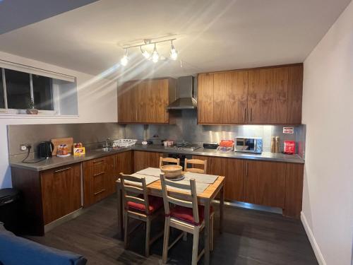 a kitchen with wooden cabinets and a table and chairs at Boyds Entry flat Old town in Edinburgh