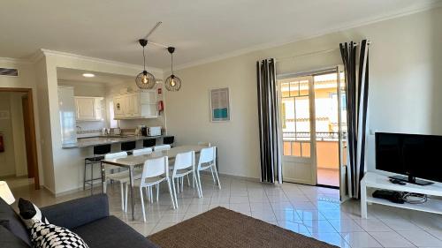 un soggiorno con divano e una cucina con tavolo di Bicos T by Check-in Portugal ad Albufeira