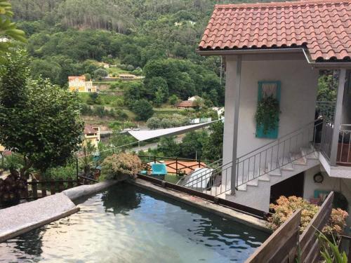 - une vue sur une maison avec une piscine d'eau dans l'établissement TEA HOUSE GERÊS, à Gerês