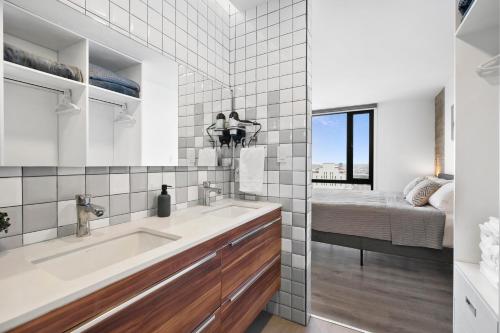 a bathroom with a sink and a bedroom at Downtown Apartment with Balcony City View, Gym & Lounge in Tijuana
