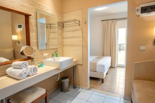 baño del hotel con lavabo y cama en Philoxenia Hotel & SPA, en Malia