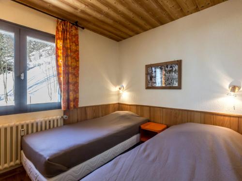 two beds in a room with a window at Appartement La Clusaz, 2 pièces, 4 personnes - FR-1-304-15 in La Clusaz