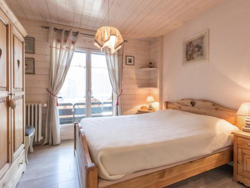 une chambre avec un lit et une grande fenêtre dans l'établissement À la Clusaz : Appartement 3* avec Garage, Proche Pistes et Commerces - FR-1-304-93, à La Clusaz